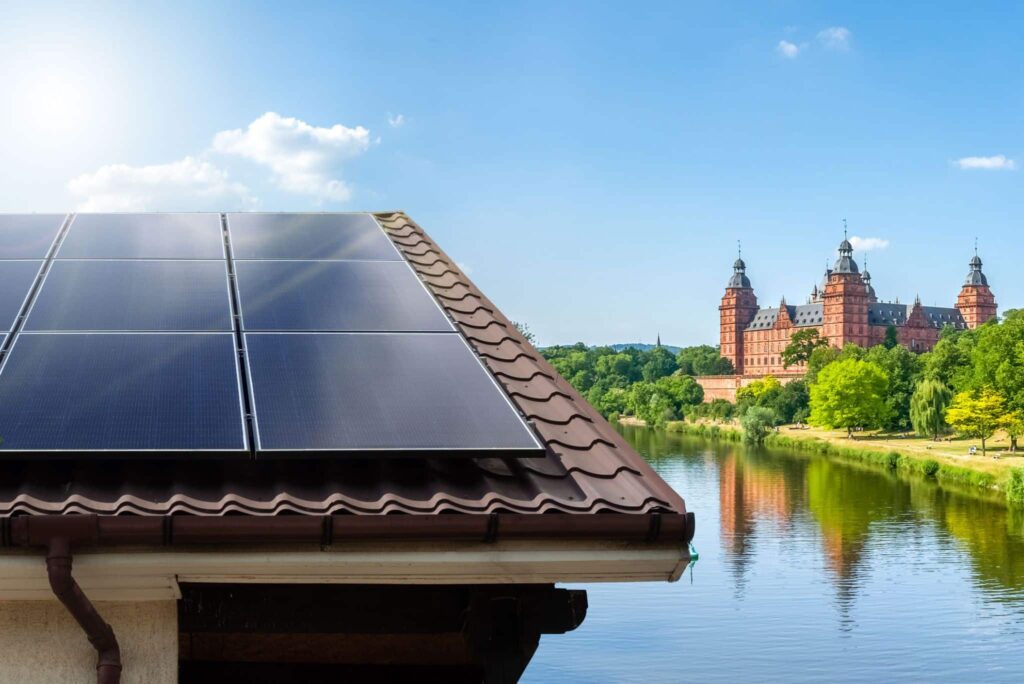 Dach mit Photovoltaikanlage und Aschaffenburger Schloss sowie der Fluss Main im Hintergrund