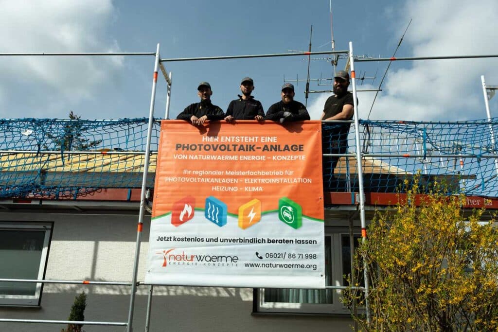 Bild von 4 Dachmonteuren auf einem Gerüst von der Firma Naturwaerme