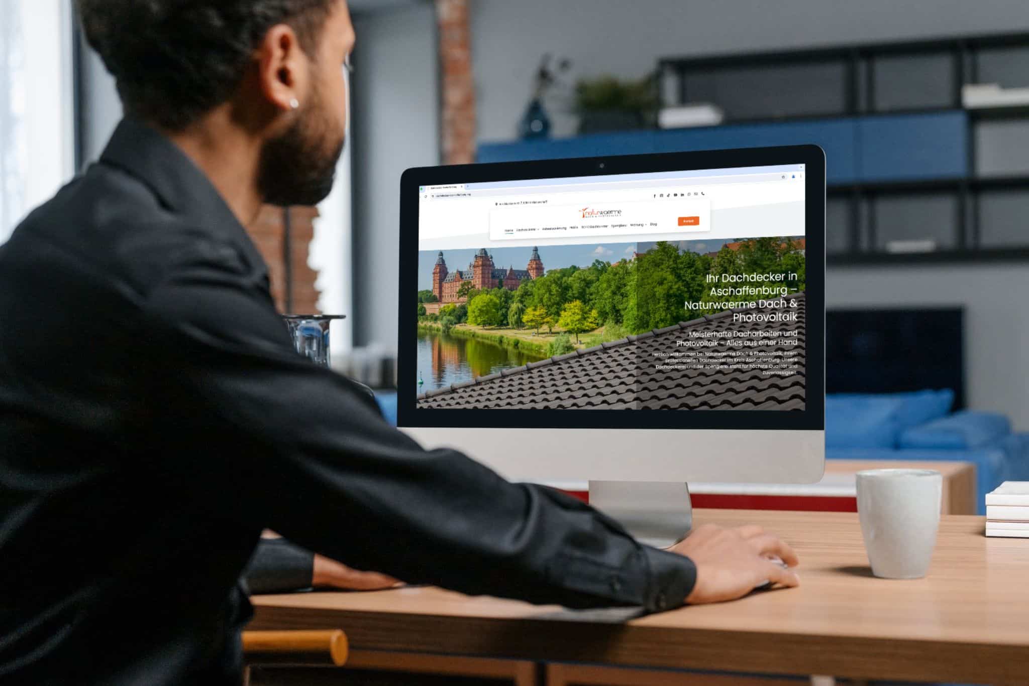 Mann am PC surft auf Dachdecker-Homepage