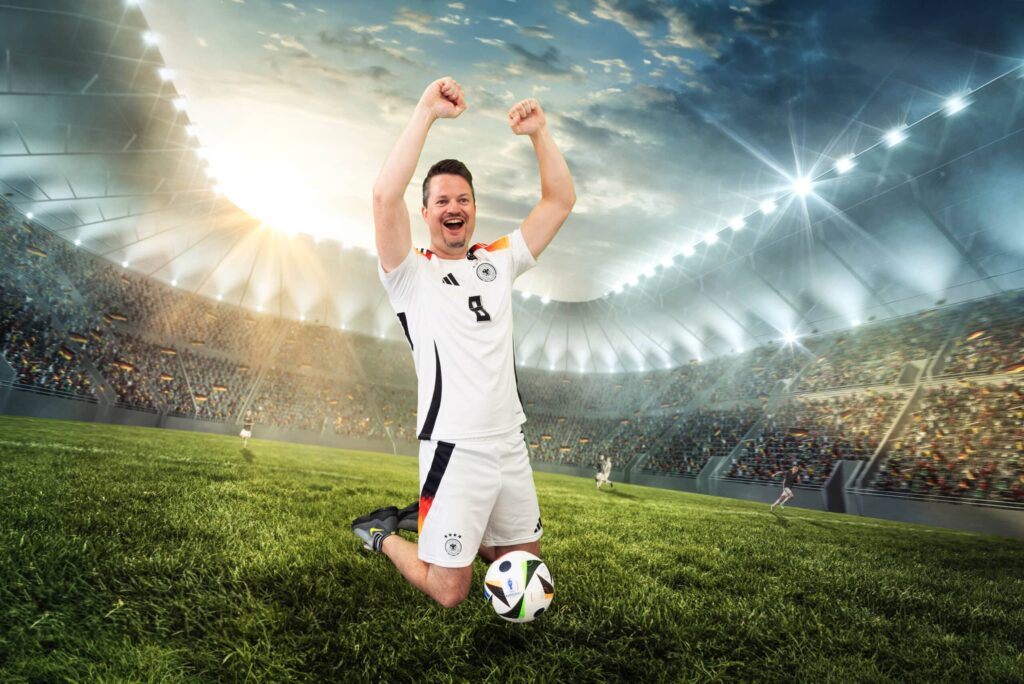 Ein Mann im Fußballstadion jubelt auf dem Rasen