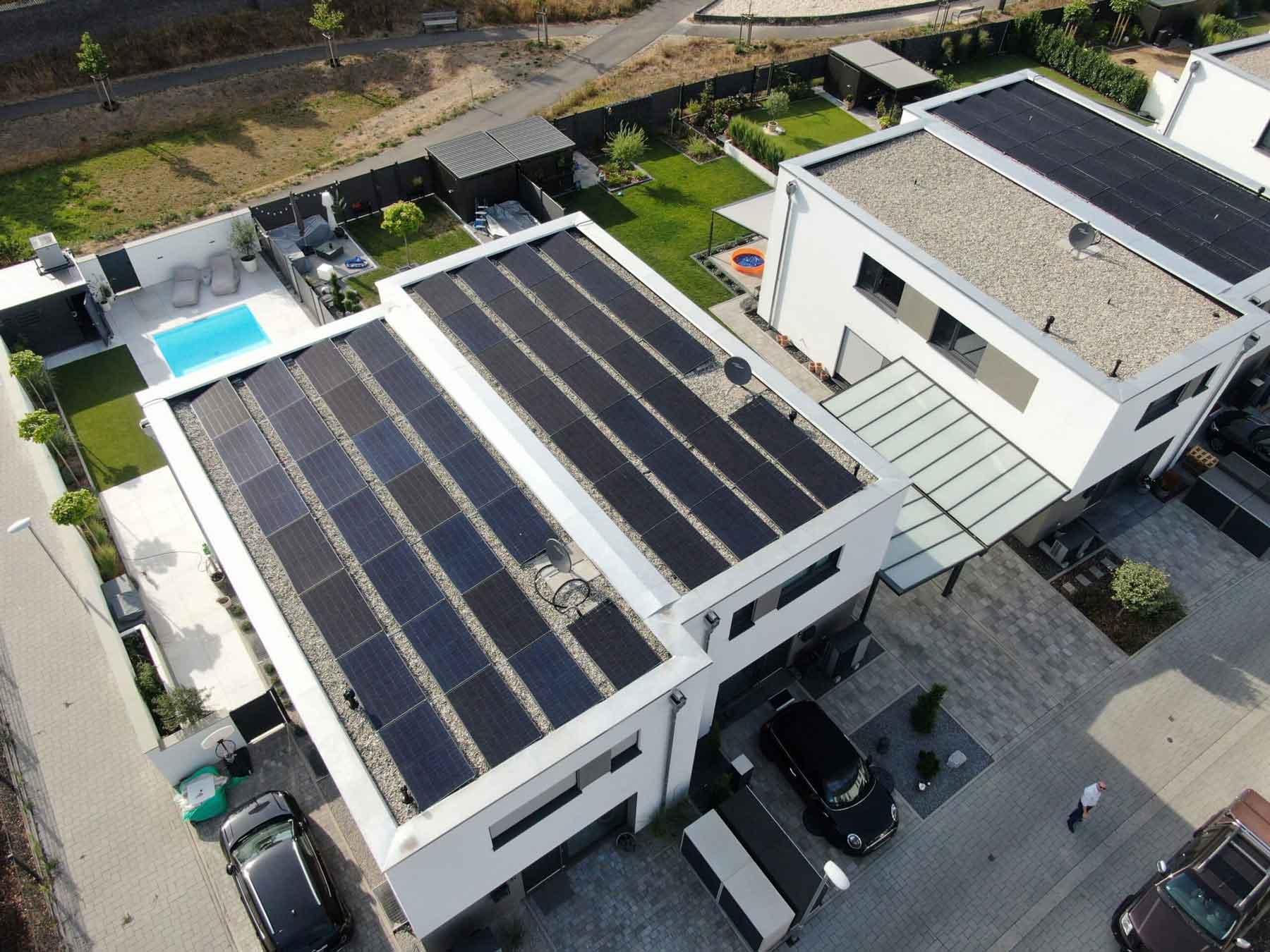 Referenzbild mit zwei Häusern und Photovoltaikanlagen mit Garten und Pool