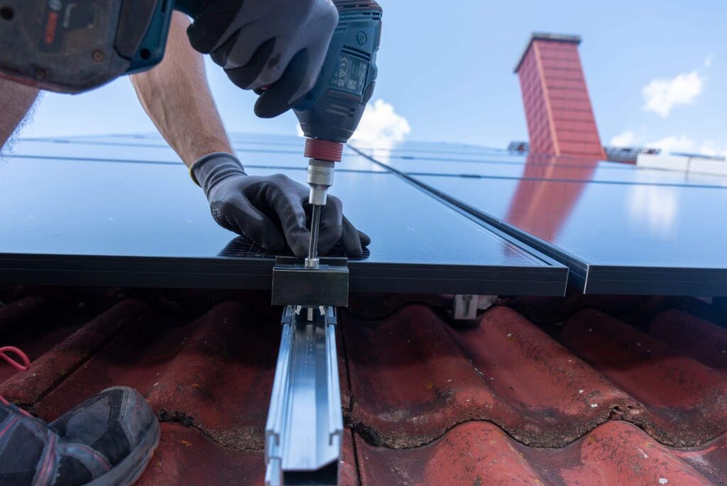 Monteur bringt Solarmodul an Dach an