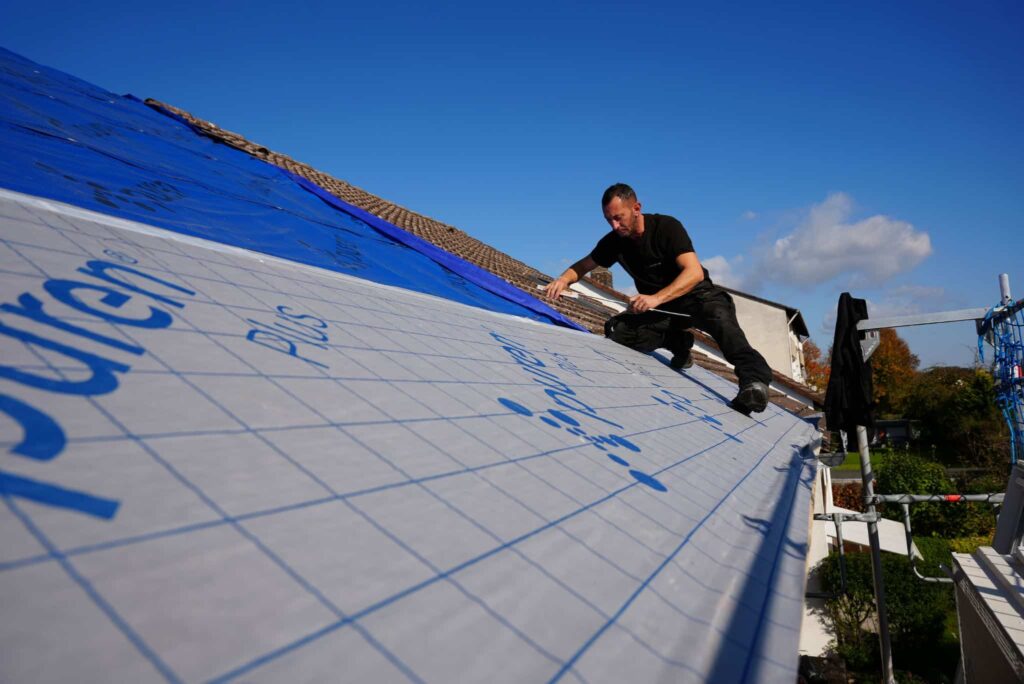 Dachdecker bei Dachsanierung, dämmt das Dach