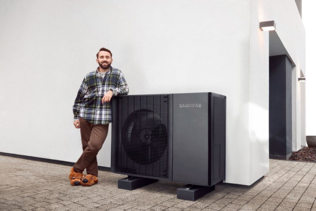 Mann steht neben Wärmepumpe