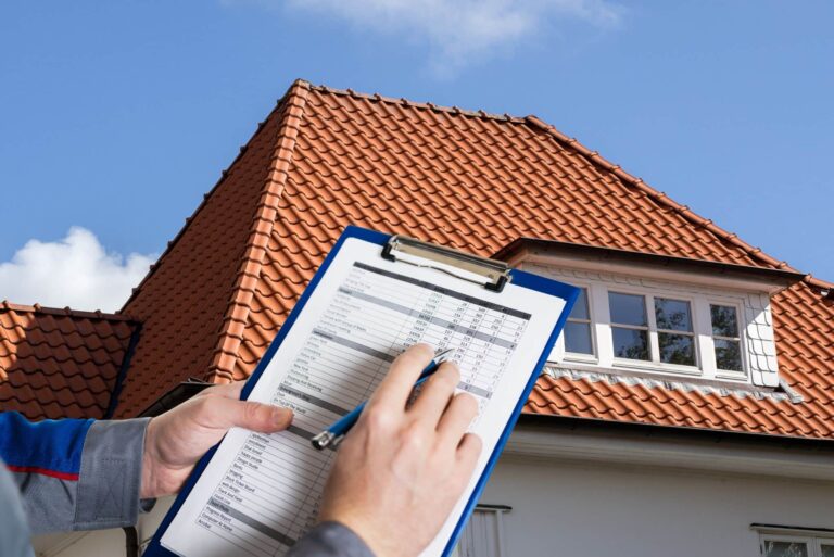 Hand hält Checkliste, im Hintergrund Dach
