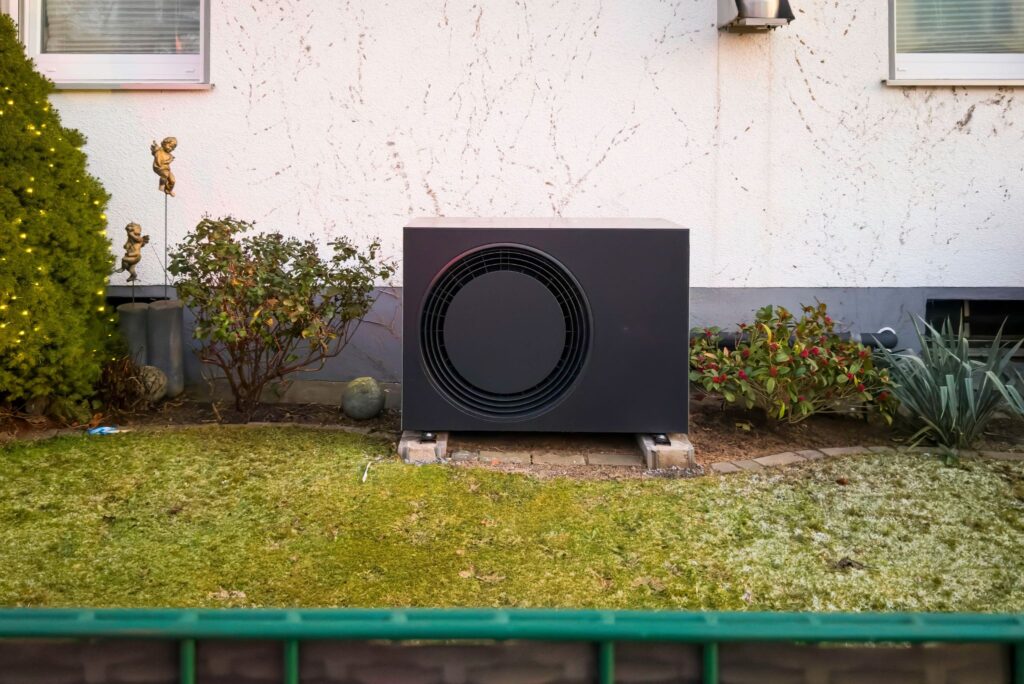Funktionsweise einer Wärmepumpe: Wärmepumpe steht vor Hauswand