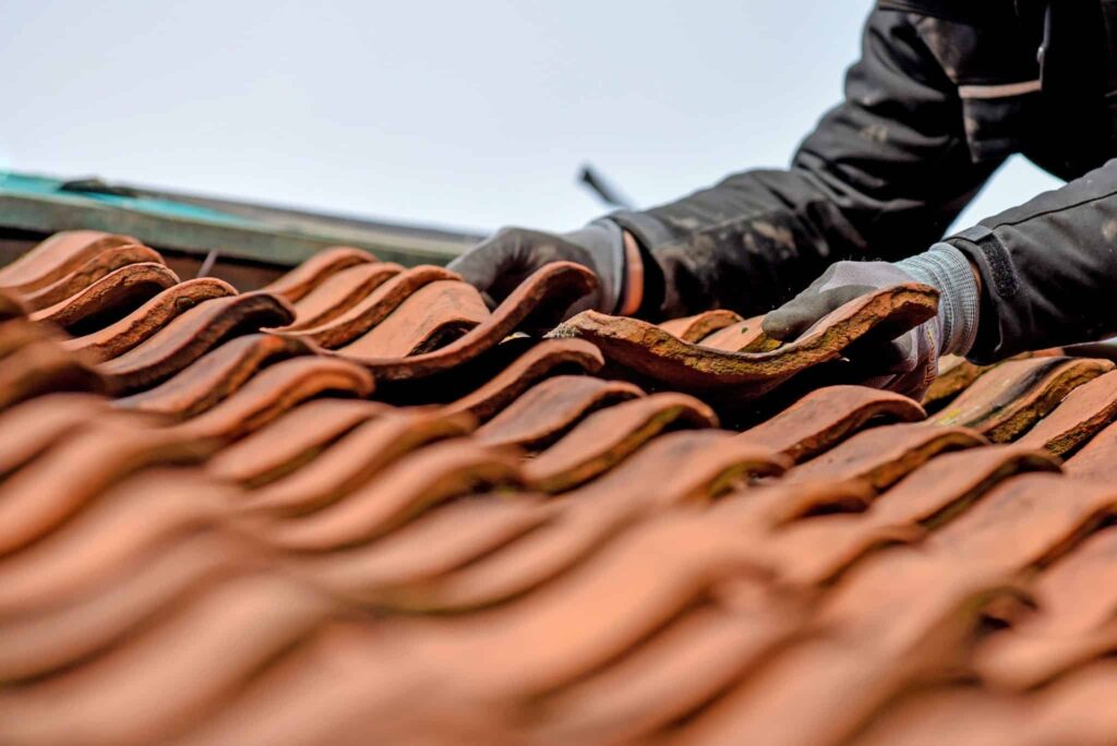 Ein Dachdecker bei der Dachreparatur