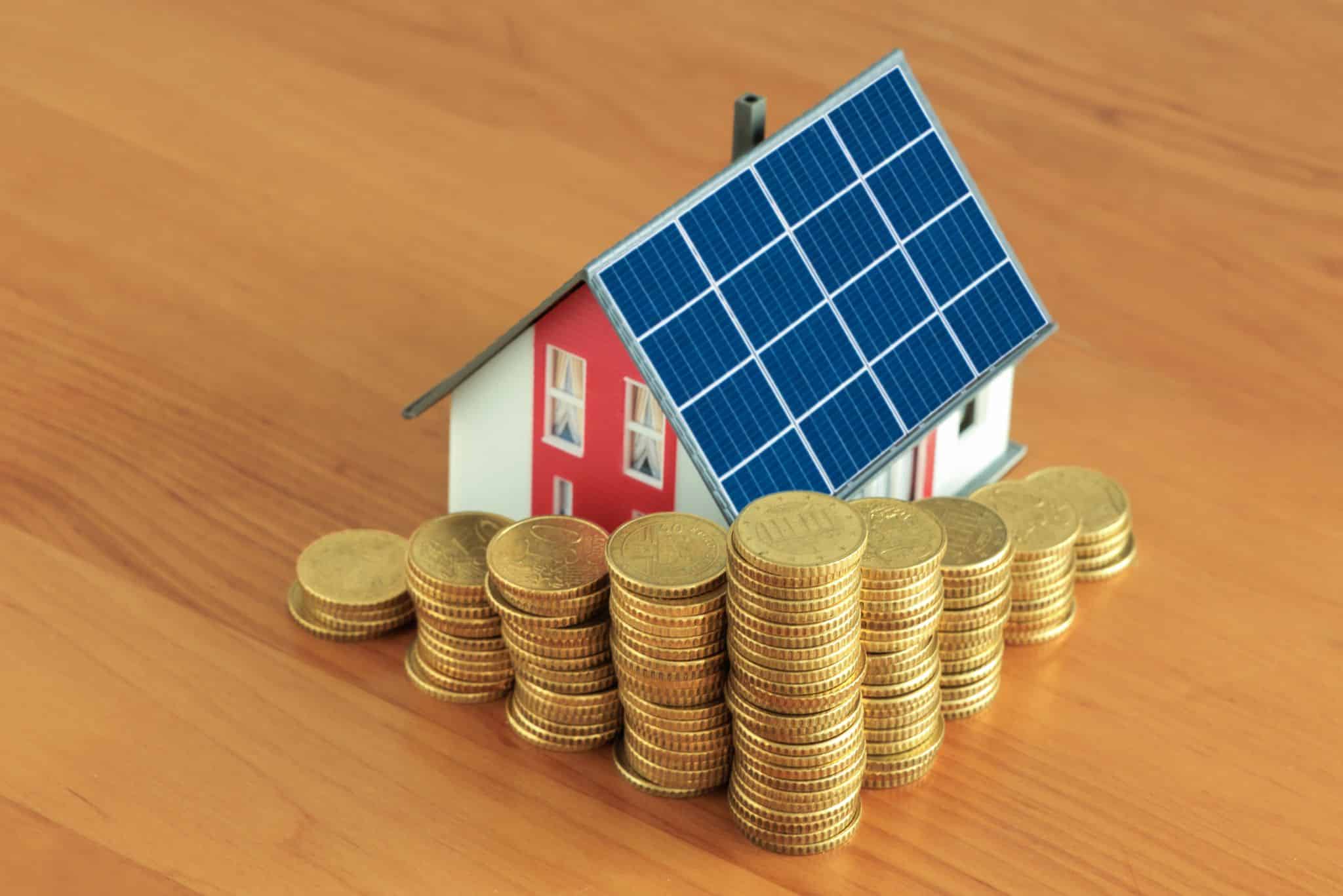Haus mit Solarmodulen und Münzen, Photovoltaikanlage Finanzierungsmoeglichkeiten